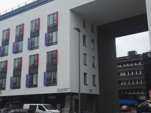 un edificio bianco con un'auto parcheggiata di fronte di Alvar, Tilava uusi kaksio ydinkeskustassa 53 m2 a Jyväskylä