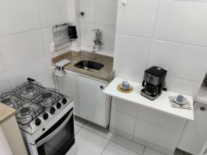 een witte keuken met een fornuis en een wastafel bij Boemia Carioca Lapa in Rio de Janeiro