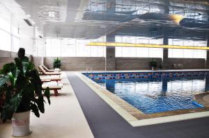 a large swimming pool in a large building at New Century Hotel Qingdao in Huangdao