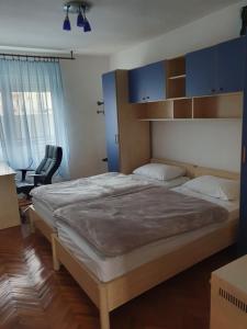 a bedroom with a large bed with blue cabinets at Apartman Noa in Knin