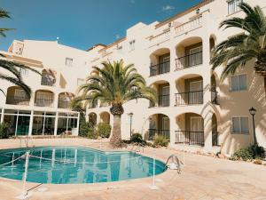 un hotel con piscina frente a un edificio en Club Simó en Cala Millor