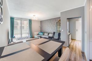 a living room with a table and a couch at Apartamenty Sun & Snow Front Park in Gdańsk