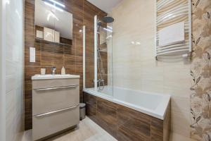 a bathroom with a sink and a toilet and a tub at Apartamenty Sun & Snow Front Park in Gdańsk