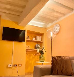 sala de estar con sofá y reloj en la pared en Piazza Napoleone Sweet apartment, en Lucca