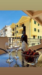 einen Tisch mit zwei Weingläsern und einer Obstschale in der Unterkunft LightHouse Apartments in Tivat