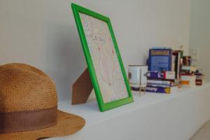 un chapeau et une photo sur une table avec des livres dans l'établissement Sirokos House, à Agios Ioannis