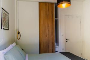 sypialnia z łóżkiem i drewnianymi drzwiami w obiekcie Sirokos House w mieście Agios Ioannis Pelio
