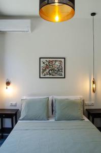 a bedroom with a white bed with two pillows at Sirokos House in Agios Ioannis Pelio