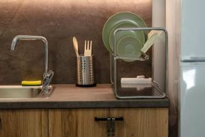 a kitchen counter with a sink and a plate and utensils at Sirokos House in Agios Ioannis Pelio +49 photos