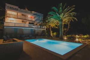 a swimming pool in front of a building at night at Seagull Pool Apartments & Studios in Novalja +38 photos