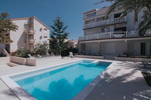a swimming pool in front of a building at Seagull Pool Apartments & Studios in Novalja