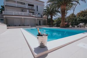 a bucket filled with wine bottles next to a swimming pool at Seagull Pool Apartments & Studios in Novalja