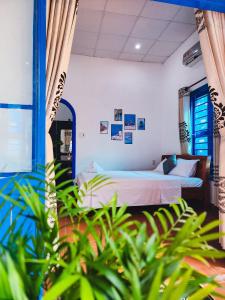2 camas en una habitación con plantas en el primer plano en Dragon Sea Homestay, en Hoi An