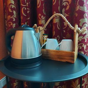 a tea kettle on a table with two cups at Citystop Majutuskeskus in Tartu