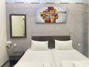 um quarto com uma cama e um quadro na parede em MR Homestay HotelStyle Room Teluk Intan em Teluk Intan