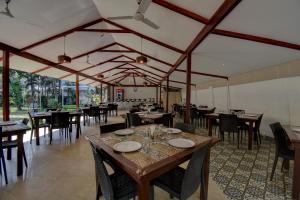 a dining room with tables and chairs in a restaurant at Peninsula Beach Resort in Calangute