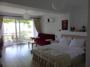 a bedroom with a large bed and a red couch at Villa Askim in Sogut