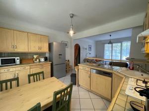 eine Küche mit Tisch und Kühlschrank in der Unterkunft Villa landaise charmante pour 6 pers avec grand jardin - Capbreton - FR-1-413-211 in Capbreton