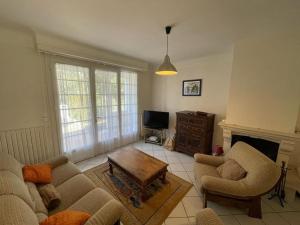 ein Wohnzimmer mit zwei Stühlen und einem Couchtisch in der Unterkunft Villa landaise charmante pour 6 pers avec grand jardin - Capbreton - FR-1-413-211 in Capbreton