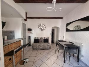 een woonkamer met een tafel en een bank bij Appartement dans ancien moulin à huile rénové in Grasse