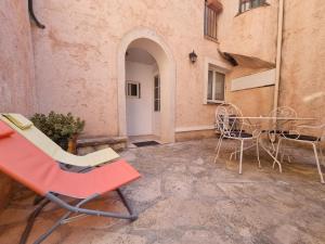 een patio met stoelen en een tafel in een gebouw bij Appartement dans ancien moulin à huile rénové in Grasse