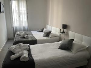 duas camas num quarto de hotel com toalhas em Hôtel Anna Livia em Cannes
