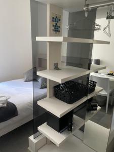 a bedroom with white shelves next to a bed at Hôtel Anna Livia in Cannes