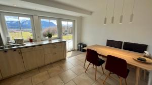 a kitchen with a wooden table and some chairs at Ferienwohnung Alpen-Panorama in Immenstadt im Allgäu