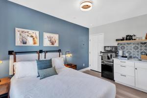 1 dormitorio con cama blanca y pared azul en Large room. Queen Bed. Workspace. Heart of Downtown, en Vista