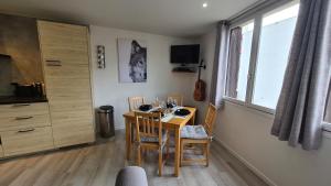 a dining room with a table and chairs and a kitchen at Serre Chevalier, Superbe appartement 5/7 couchages in Saint-Chaffrey