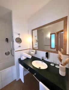 ein Bad mit einem Waschbecken und einem Spiegel in der Unterkunft Landhotel Stegersbach in Stegersbach
