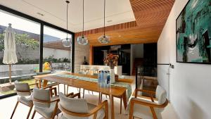 een eetkamer met een tafel en stoelen bij West Phu Quoc Charm 3BR private pool villa in Phu Quoc