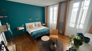 1 dormitorio con cama y pared azul en Jardin Bleu - Chambres d'hôtes, en Saint-Girons