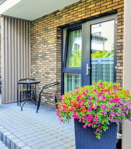 a patio with a table and a pot of flowers at Amber Drop apartments in Palanga