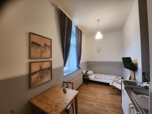 ein kleines Wohnzimmer mit einem Tisch und einem Fenster in der Unterkunft Studio-Apartments & möblierte Wohnungen zentral in Mülheim an der Ruhr, ideal für Geschäftsreisende und Monteure in Mülheim an der Ruhr