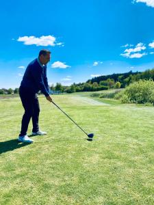 facet gra w golfa na polu w obiekcie Landhotel Stegersbach w mieście Stegersbach
