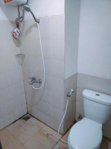 a bathroom with a toilet and a shower at Room Apartemen by GIANDARA in Sayang