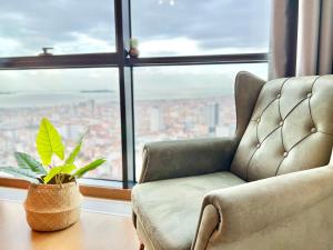 a chair and a plant on a table in front of a window at RITIM ISTANBUL SKYHOUSES in Istanbul