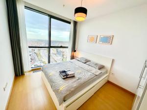 a bedroom with a bed with a large window at RITIM ISTANBUL SKYHOUSES in Istanbul