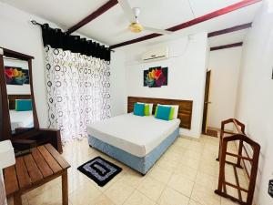 a bedroom with a bed and a chair in it at Tishan Holiday Resort in Polonnaruwa