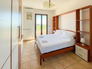 a bedroom with a white bed and a window at Homiday - Villa Mila in Pineto