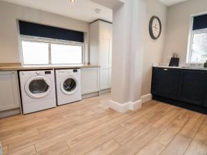 a laundry room with a washer and dryer at Tan Y Fron in Penrhyn Bay