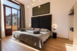 - une chambre avec un grand lit et une grande fenêtre dans l'établissement B&B Soggiorno Battistero, à Florence