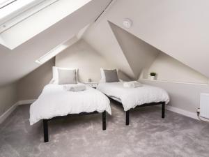 2 camas en un ático con paredes blancas en Tan Y Fron en Penrhyn Bay