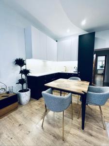 - une salle à manger avec une table et des chaises dans l'établissement MH Luxury Apart, à Poznań