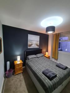 a bedroom with a bed with two night stands and two lamps at North Face Apartment , Fort William in Torlundy