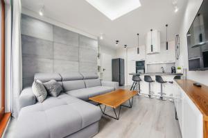 a living room with a couch and a table at Apartamenty Sun & Snow Nowa Motława in Gdańsk