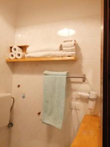 un bagno con servizi igienici e asciugamani su una mensola di B&b Oltre l'Arco a Molfetta