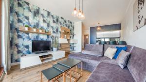 - un salon avec un canapé et une télévision dans l'établissement Apartamenty Sun & Snow Nowa Motława, à Gdańsk