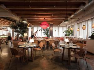 a restaurant with tables and chairs and people in the background at Hesperia Sevilla in Seville